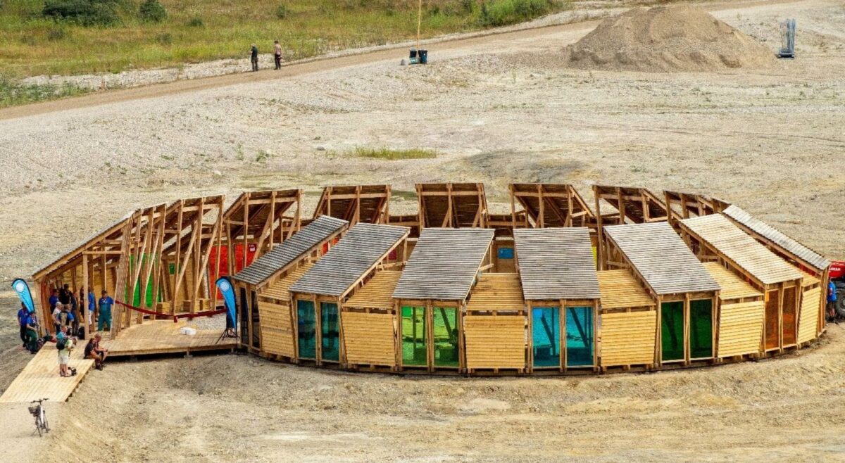 Den knap 29 meter brede 'læringsspiral' med sytten overdækkede, halvåbne hytter med vinduer i verdensmålenes farver er det bærende element i det nye vartegn for Spejdernes Lejr 2022. Foto: Elena Moeberg