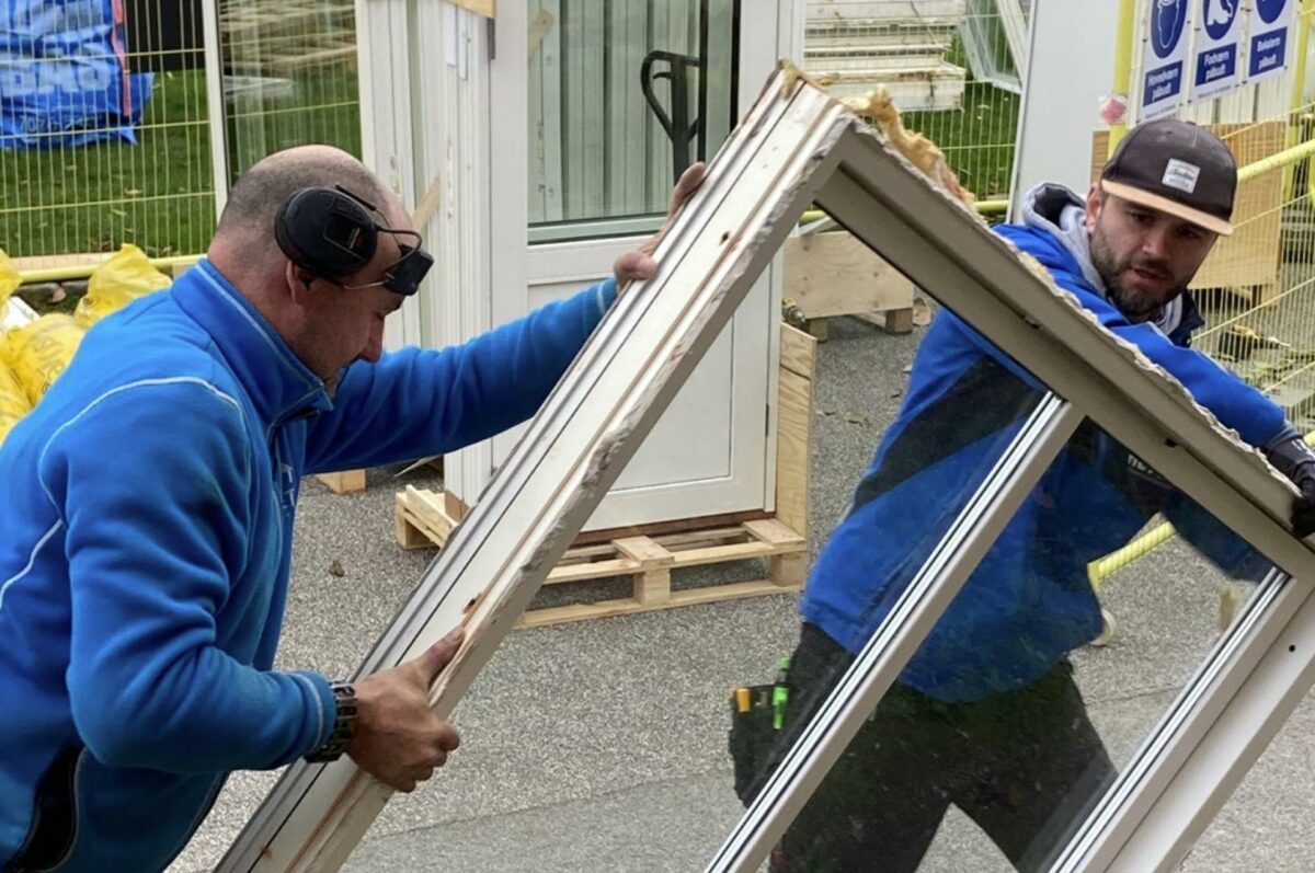 De gamle vinduer, som Jesper Olander Krogh Nielsen (tv.) og Tobias Kuntze fra Heto her bærer ud fra Egevang Nord i Søllerød, bliver omdannet til nye, brugbare produkter som spånplader og vinflasker. Foto: Heto