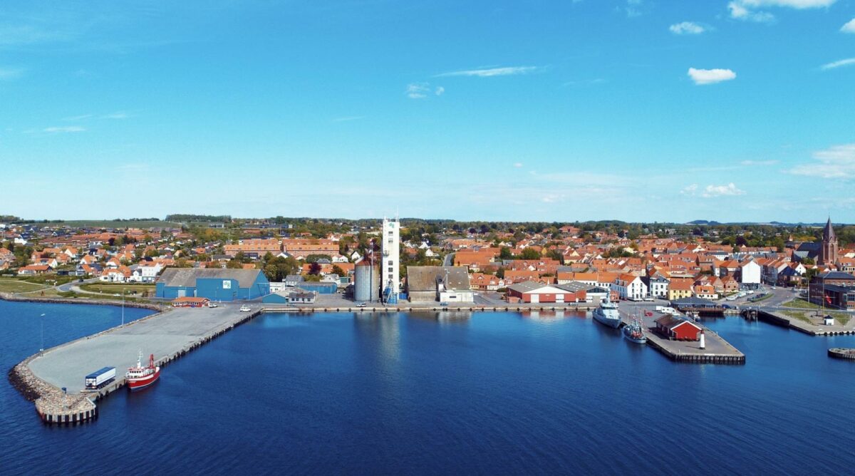 Det røde pakhus på midtermolen på Assens Havn er bygget i 1884, og skal indtænkes som en del af det kommende nationale kyst- og lystfiskercenter på stedet. Foto: AK Dronefoto