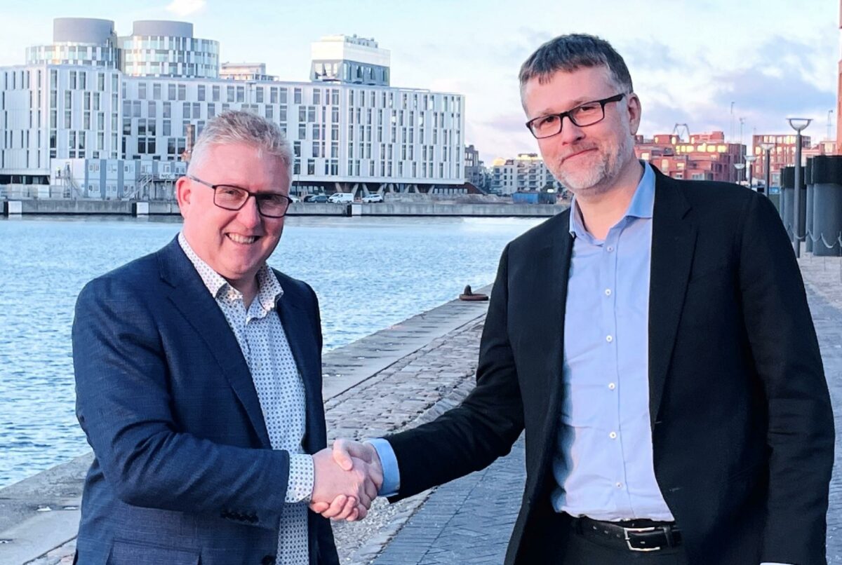 Koncerndirektør Henrik Mielke, MT Højgaard (tv) og koncerndirektør hos Nordic Wood Industries, Thomas Raunsbæk giver håndslag på Scandi Bygs fremtid hos trækoncernen.