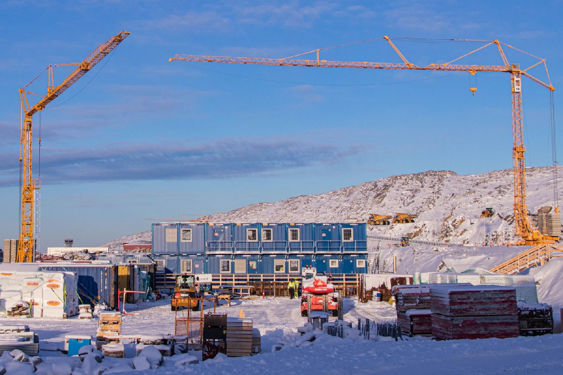 Byggekranerne knejser i øjeblikket side om side i Nuuk. Går man lidt op på fjeldet uden for byen, kan man lige nu tælle intet mindre end 25.