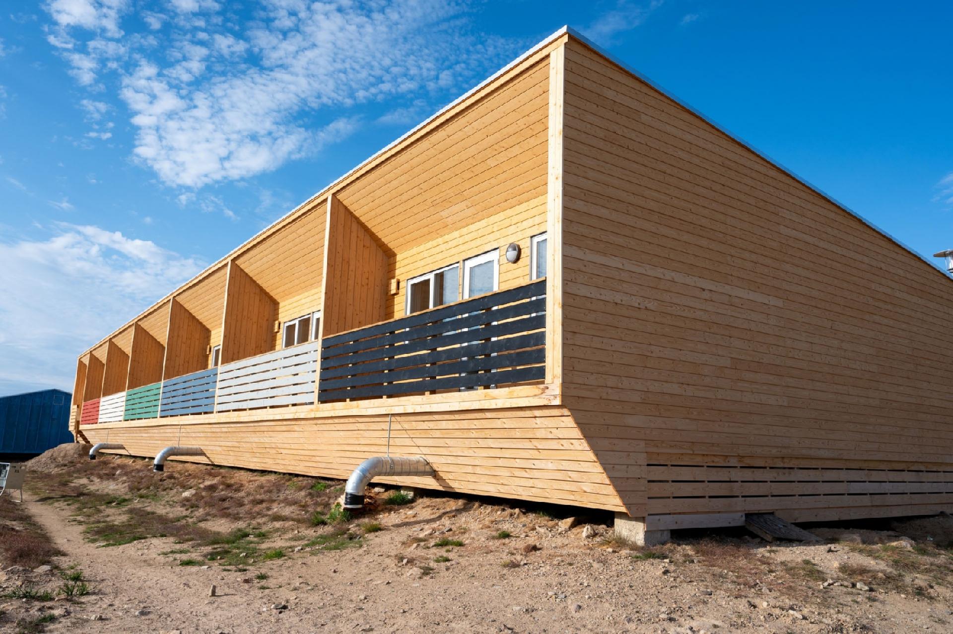 Når det nye Bygningsreglement skal vedtages i sommeren 2024, kommer det blandt andet til at indeholde langt skrappere krav til energiforbruget. Hensigten er at reducere det i nyt byggeri med op til 25-30 %. Her ses en stribe nybyggede ungdomsboliger i Qaanaaq. Foto: HJ Greenland