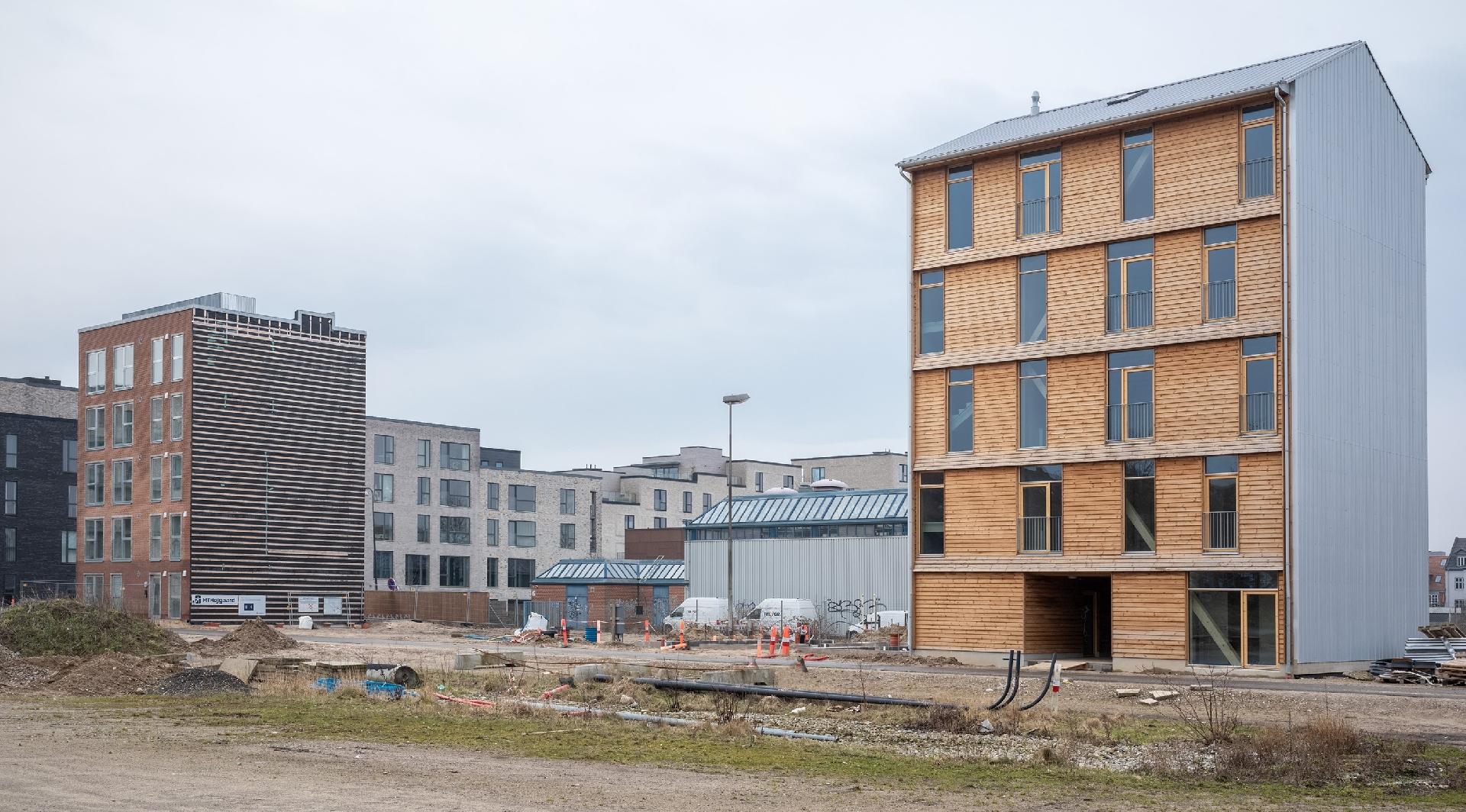 Til venstre ses MiniCO2 Etagehus Digital, mens MiniCO2 Etagehus Træ står til højre. Ved siden af træhuset bliver etagehuset i beton opført i løbet af 2025. Foto: Helene Høyer Mikkelsen