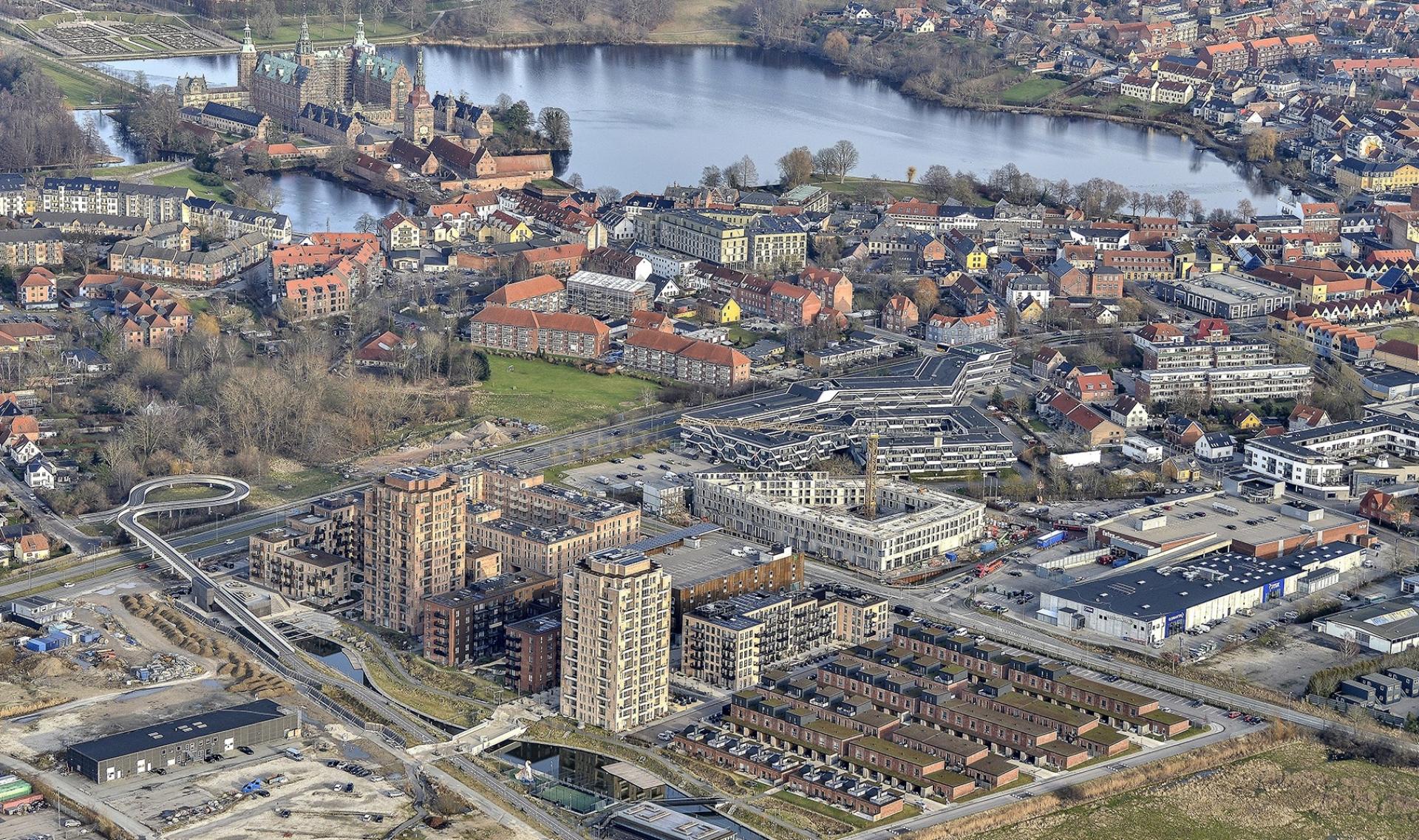 Den nye boligkarré ligger som blommen i et æg i Hillerød. Fra tagterrasserne vil der være udsigt til bl.a. Frederiksborg Slot og det nybyggede boligkvarter Frederiksbro med bl.a. de to boligtårne lige på den anden side af Roskildevej.