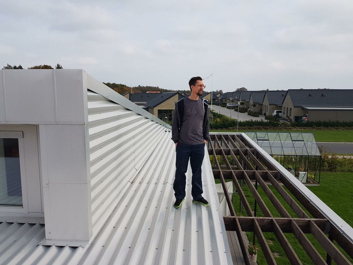 Der er holdbarhed i aluminium og minimal vedligehold, selv om produktionen af metallet sviner. Thomas Storm nyder udsigten fra sit tag. Foto: Thøger Raun.