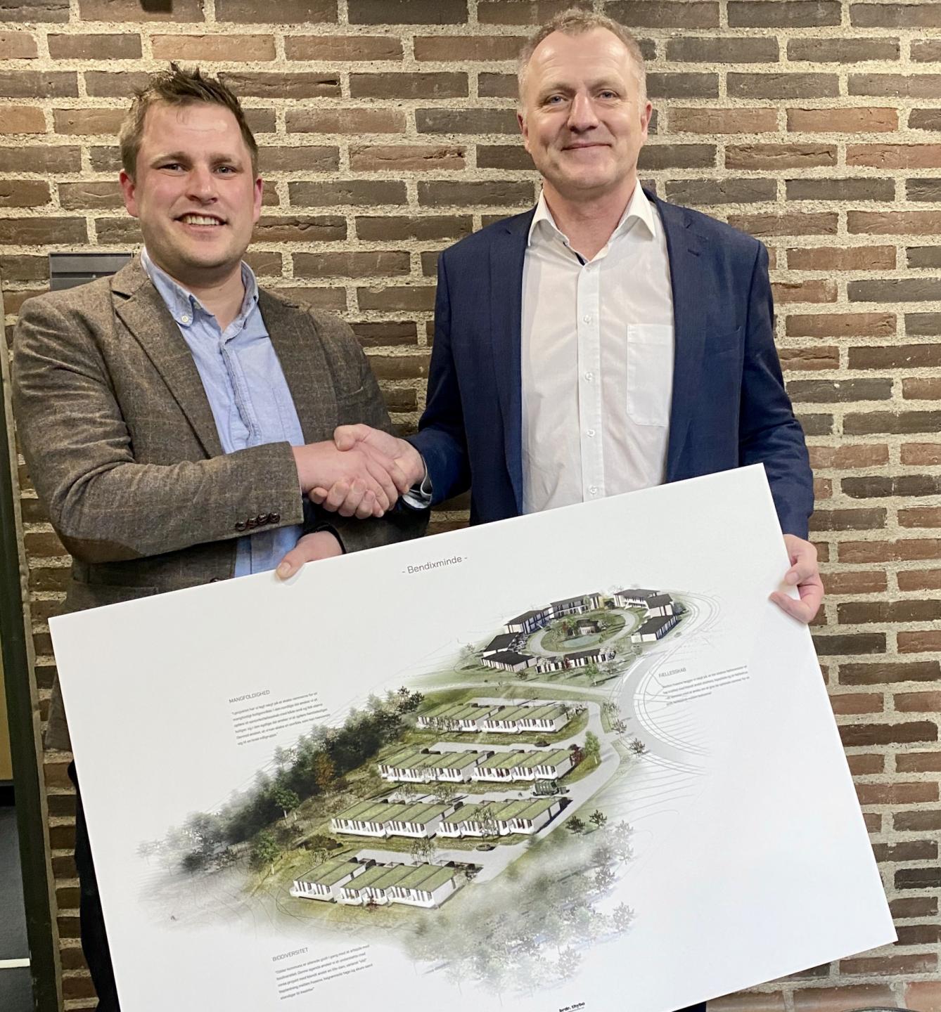Rasmus Kjær fra brdr. thybo og borgmester Uffe Jensen fra Odder Kommune giver hånd på det nye samarbejde om et boligbyggeri i Bendixmide. Foto: Odder kommune.