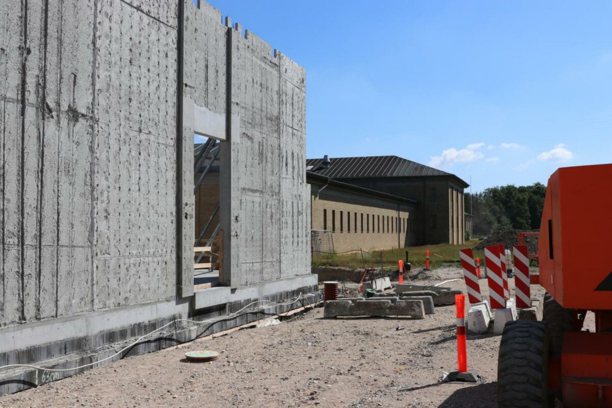 Når den nye bygning (til venstre) er færdig og taget i brug, skal den gamle gule murstensbygning nedtages og genopbygges. Foto: Torben Jastram.