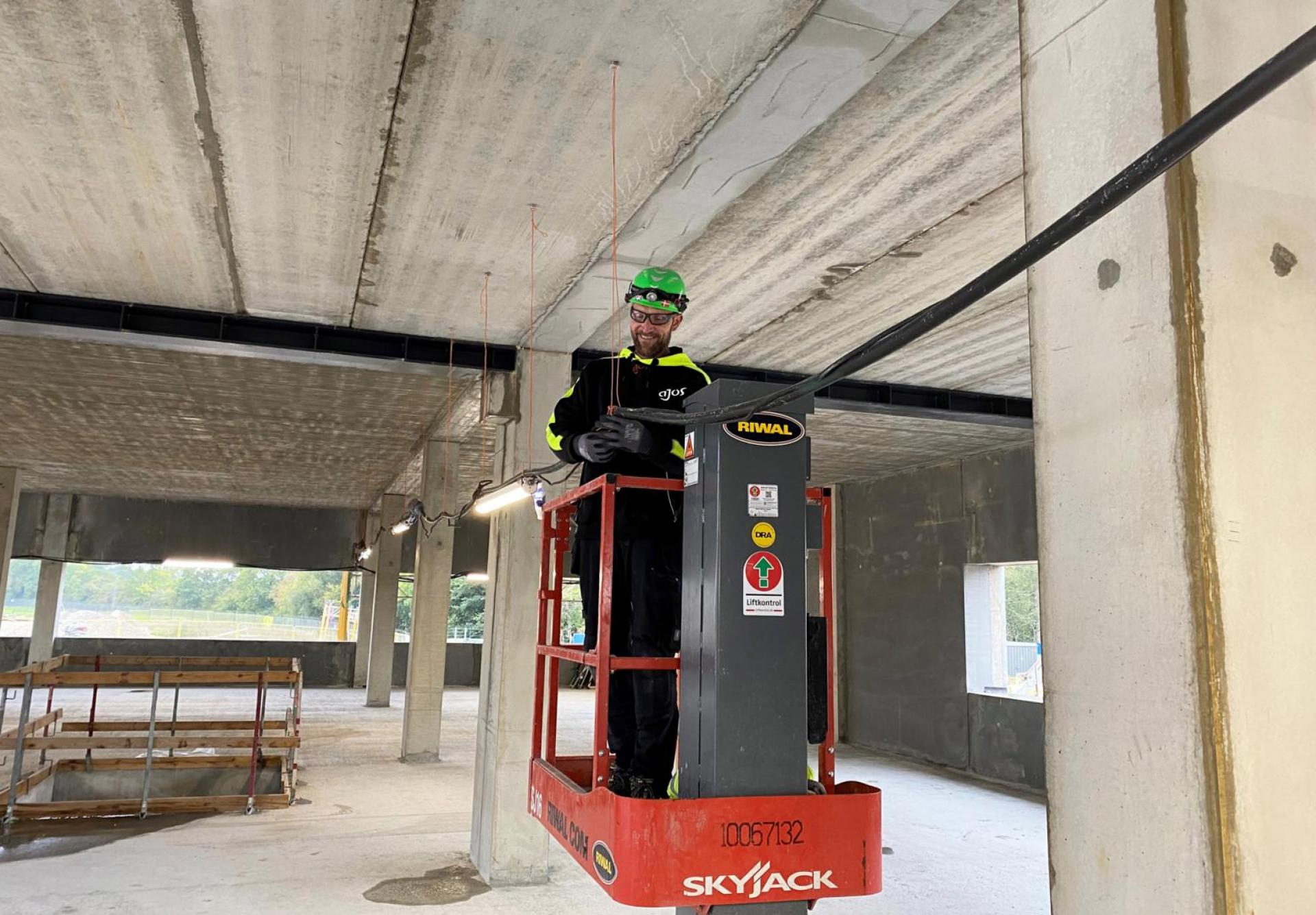 Elektriker Torben Steen Nielsen monterer LED-armaturer indvendigt i byggeriet. Pressefoto.