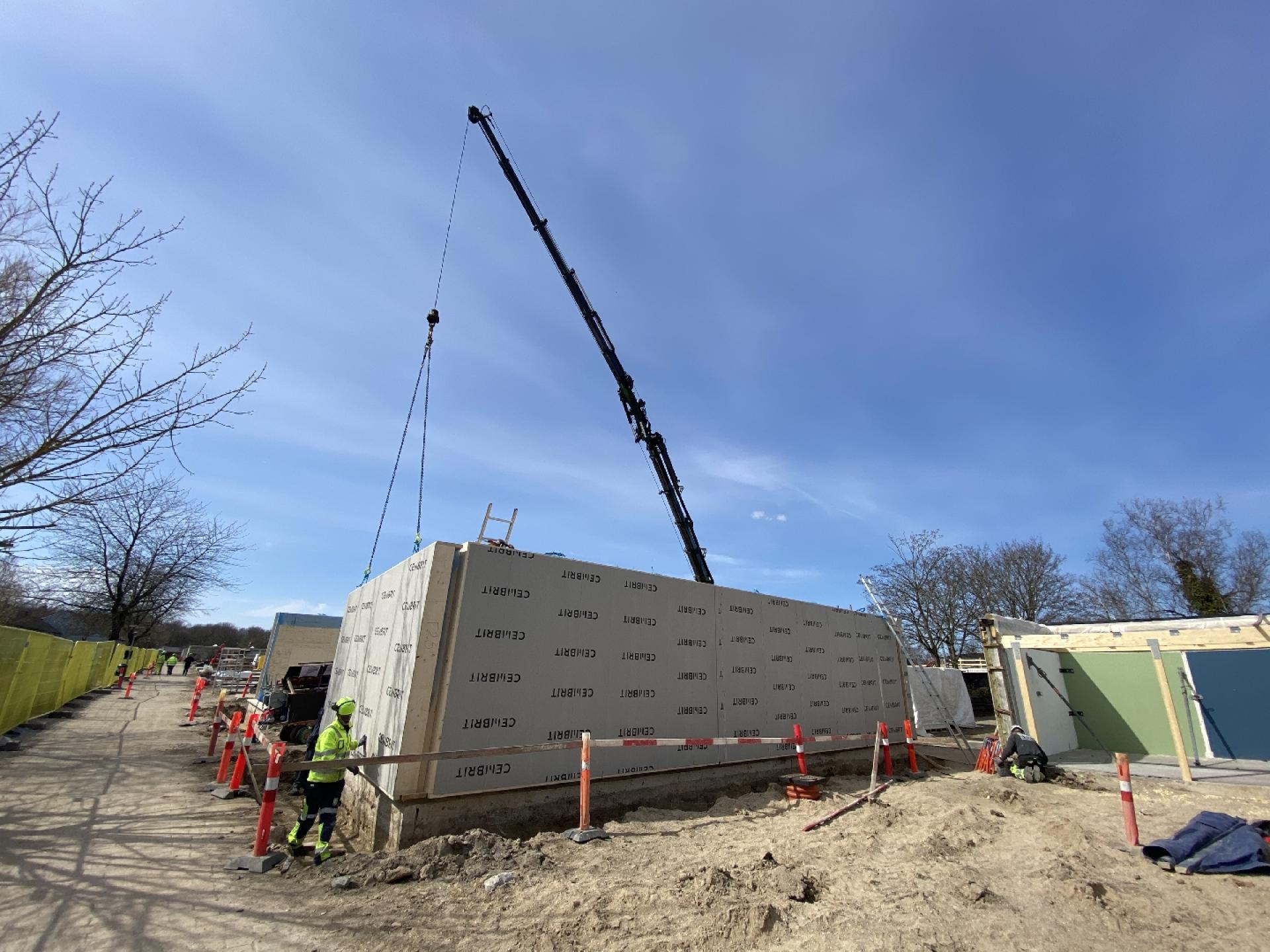 På et tidspunkt var kun fundamentet under det oprindelige gårdhavehus tilbage. Her hejses nye vægelementer på plads. Foto: NCC