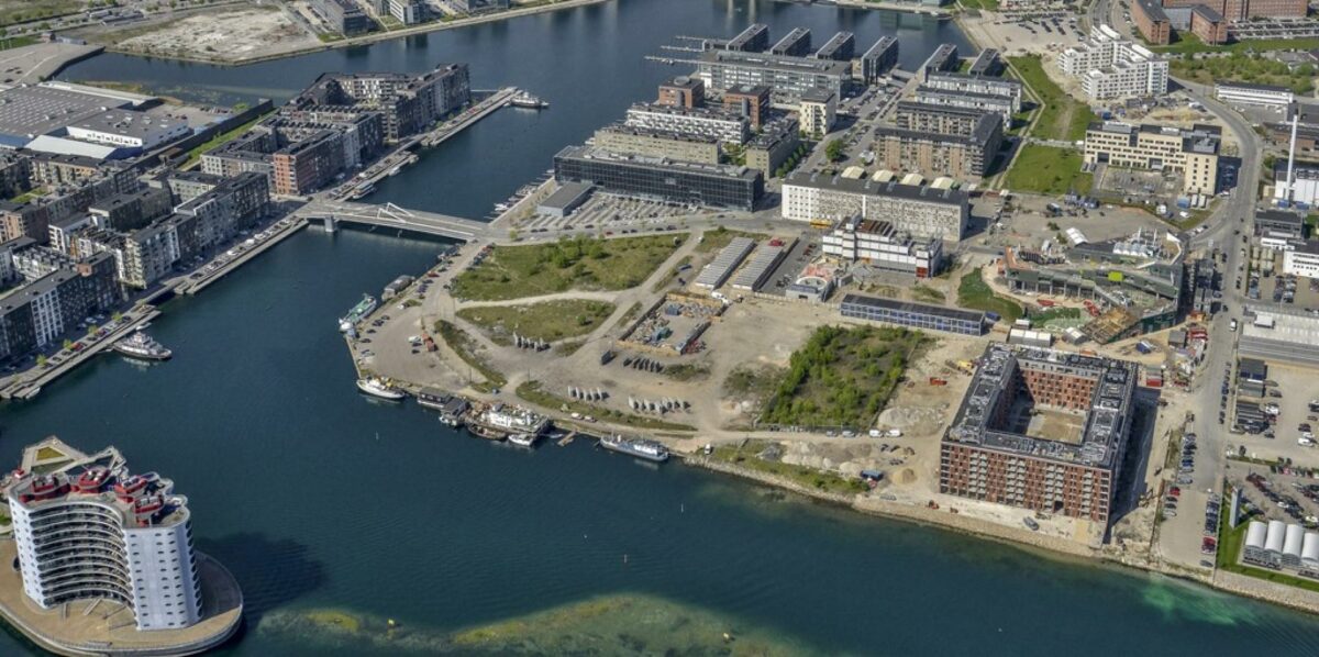 By & Havn har netop solgt fire grunde på Teglholmen. Til højre for de tomme byggegrunde ses "Bolværket", og lige bag dette byggeri opfører Københavns Kommune en skole. Foto: Sjælsø Management.