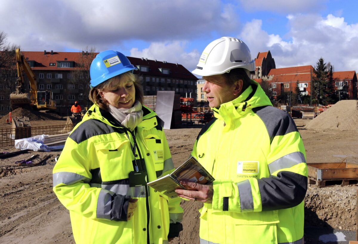 Entreprisechef Carsten Nyboe og overordnet sikkerhedskoordinator Hanne Schack Blichmann med den nye sikkerhedshåndbog, der skal sætte fokus på sikkerhed og trivsel på byggepladserne på Nyt Hospital og Ny Psykiatri Bispebjerg. Foto: Louise Bendixen.