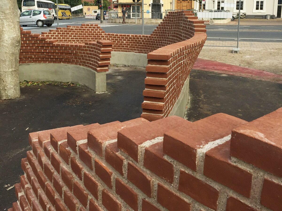 I Odense har 12 murerlærlinge de seneste uger skiftet murersnoren ud med højteknologiske 3D-skabeloner og bygget en krum mur. Pressefoto.