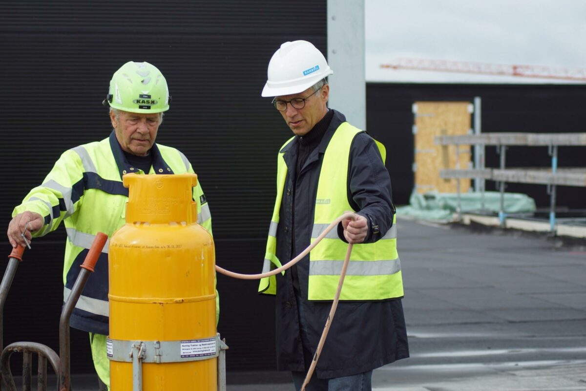 Finn Sørensen fra Icopal viser en af sommerens gode ideer til forbedring af arbejdsmiljø frem for arbejdsmiljøchef på DNV-Gødstrup, Åge Staghøj. Foto: Morten Korsgaard/Rambøll.