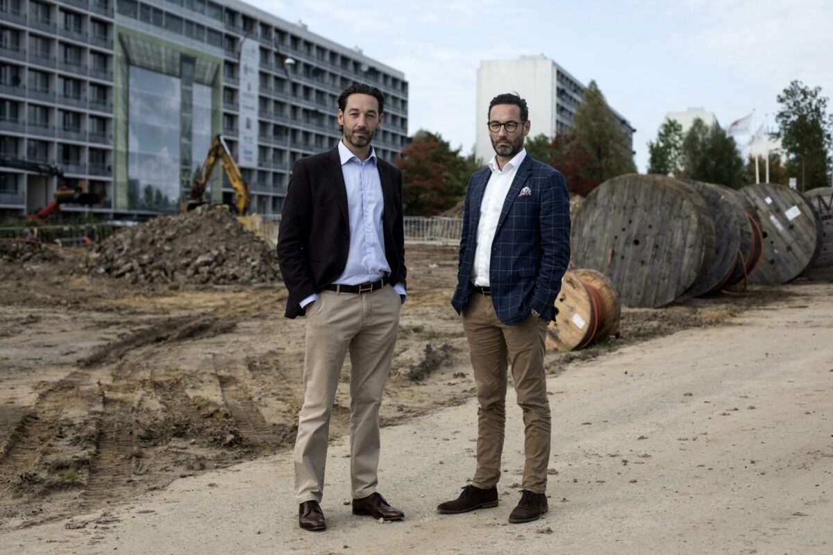 Brødrene Michael og Morten Brixhuus på grunden, hvor de skal bygge et nyt kvarter ved siden af Gellerupparkens blokke. Foto: Betina Garcia