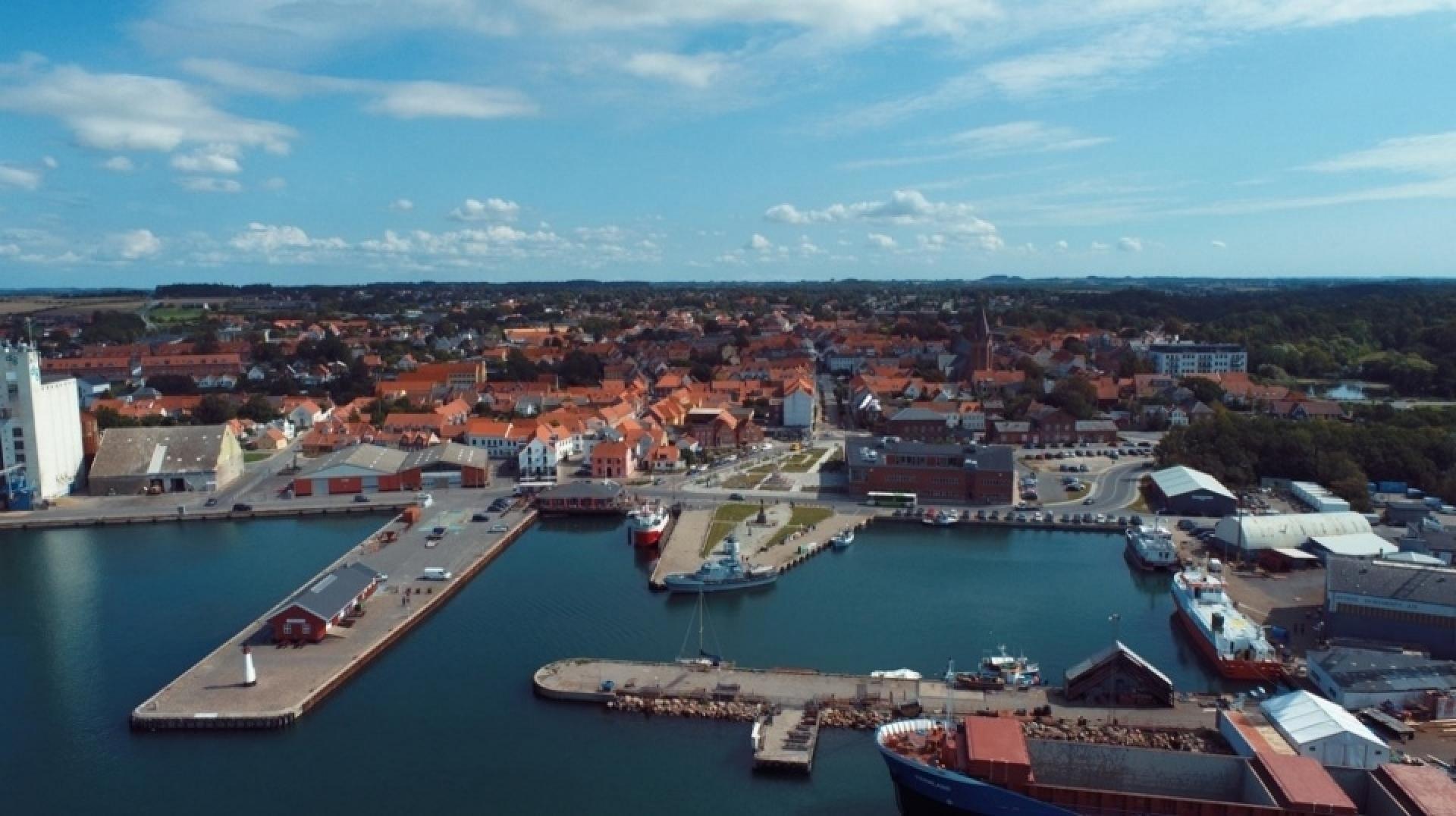 Danmarks kommende Kyst- og Lystfiskercenter, der skal ligge her på Assens havn, skal spille sammen med det gamle pakhus og havnens øvrige faciliteter. Foto: Assens Kommune