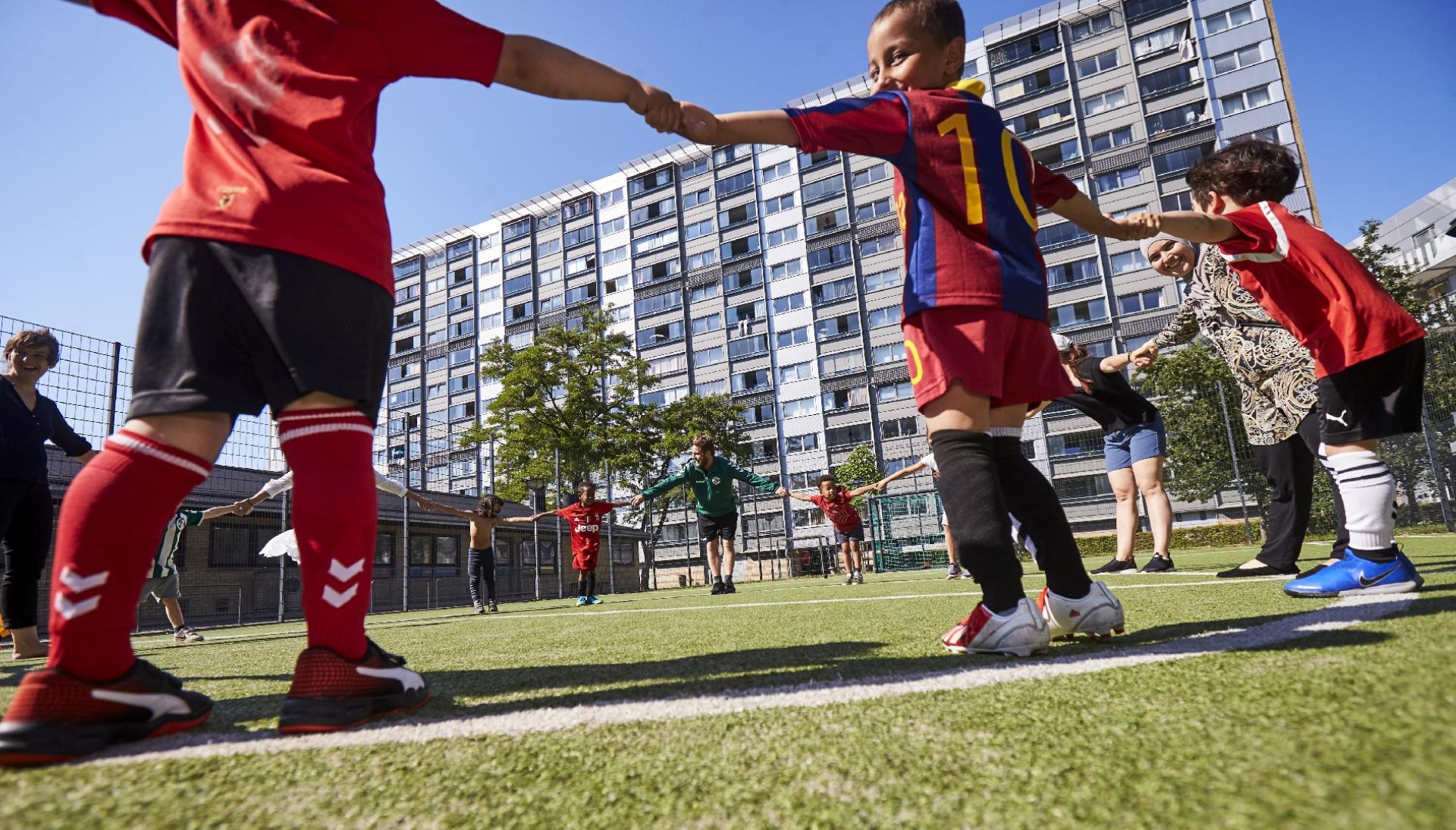 Fodboldbanerne skaber liv mellem blokkene - men afskærmer også mod områdets øvrige liv. Det skal der nu ændres på. Foto: Claus Sletting/DBU København