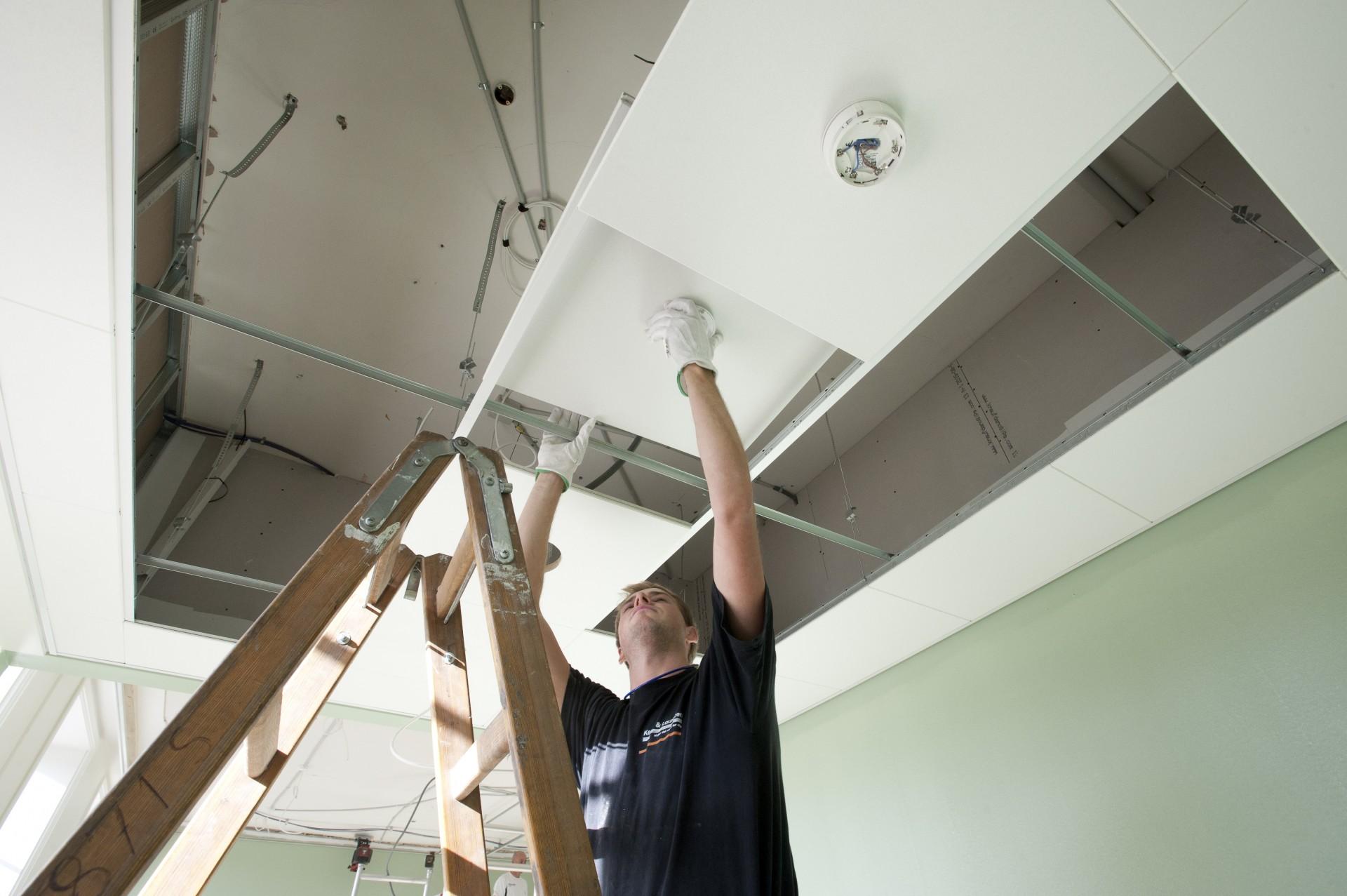 Knauf er komplet leverandør af akustiske lofter i både gips, mineraluld og træbeton. Her er tømreren fra Jakon i gang med at installere Thermatex Alpha-minerauldsloft. Pressefoto.