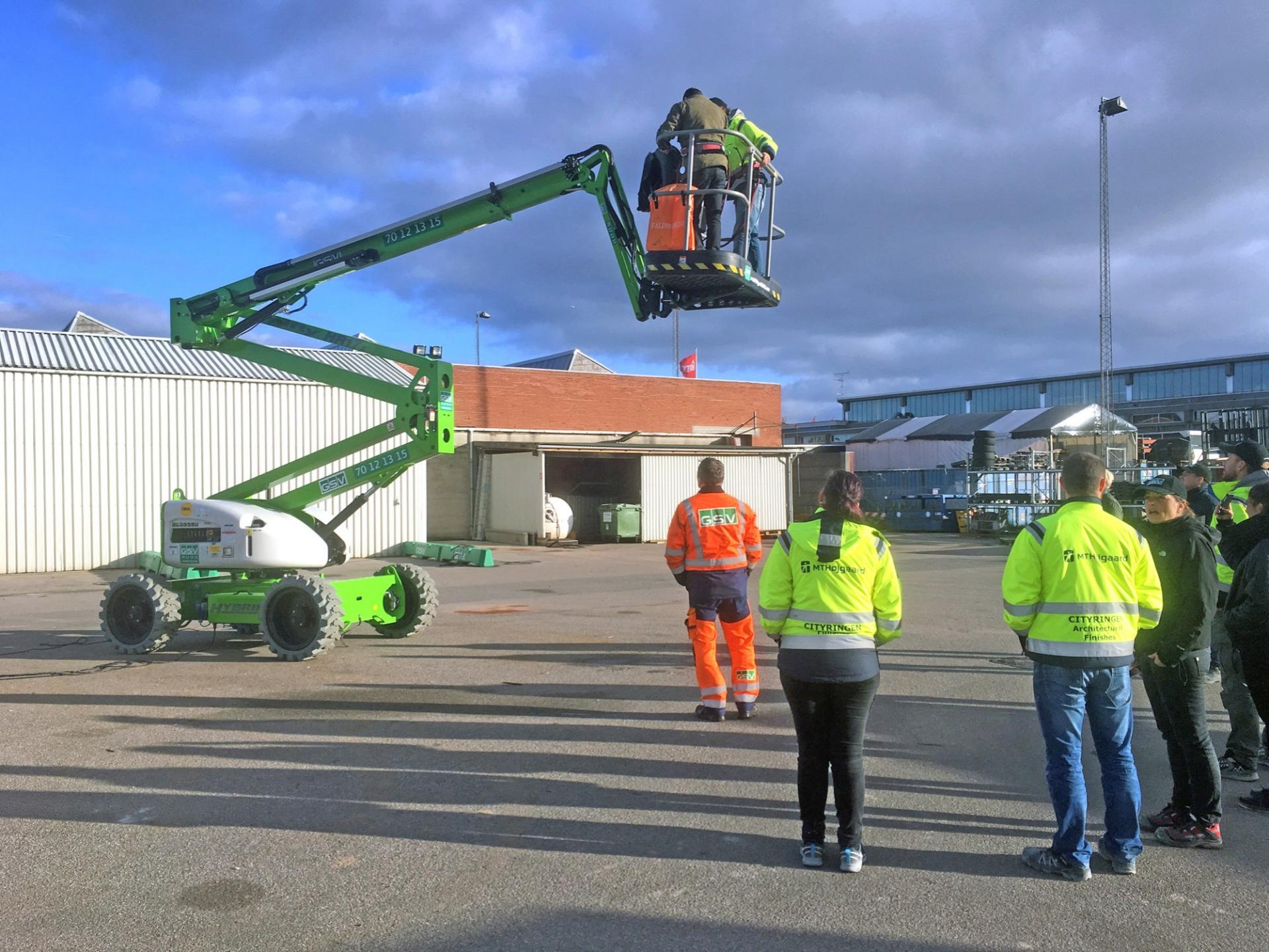 Her er nogle af deltagerne ved at modtage instruktion i kørsel med en hybriddrevet knækarmslift. Pressefoto.