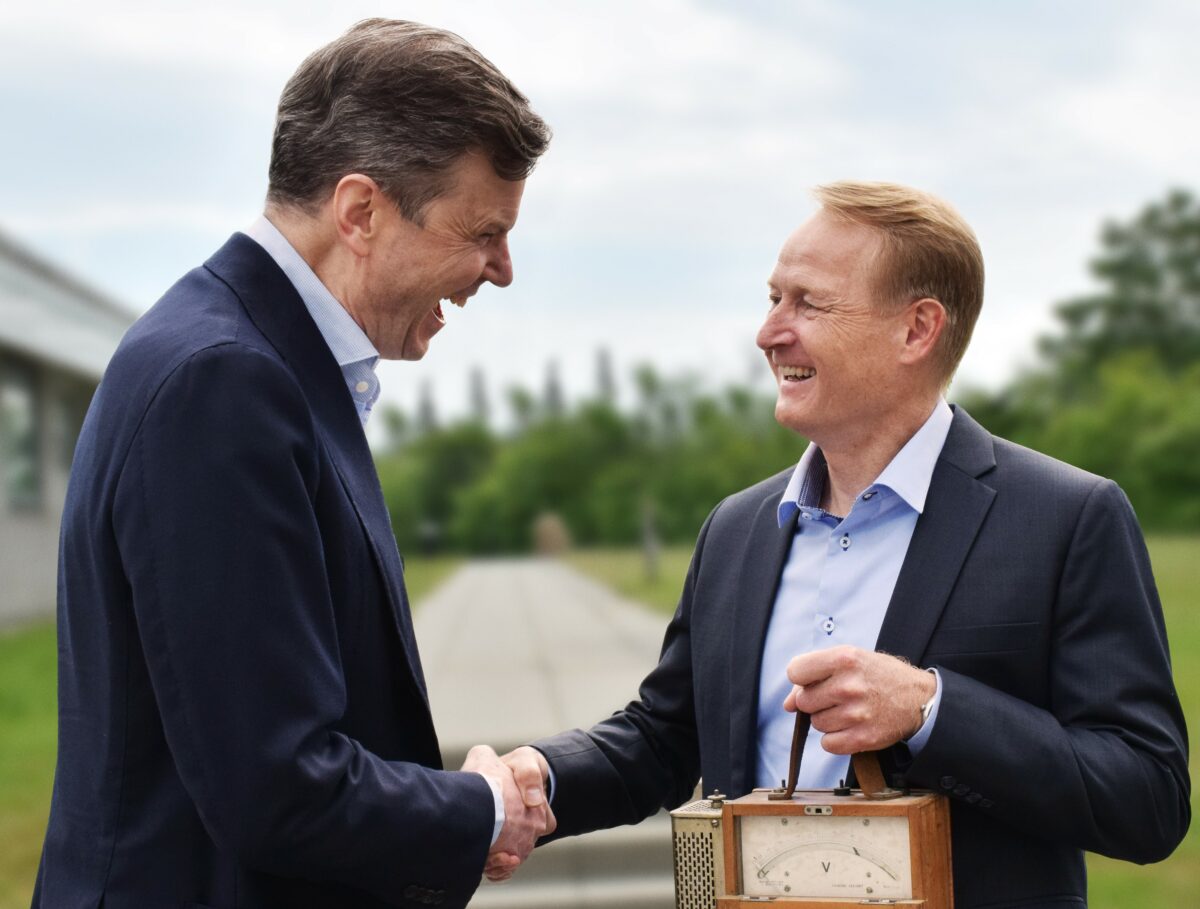 Frank Müntzberg (tv.) griner sammen med Henrik Støwer Petersen, der står med et gammelt, brunt el-apparat.