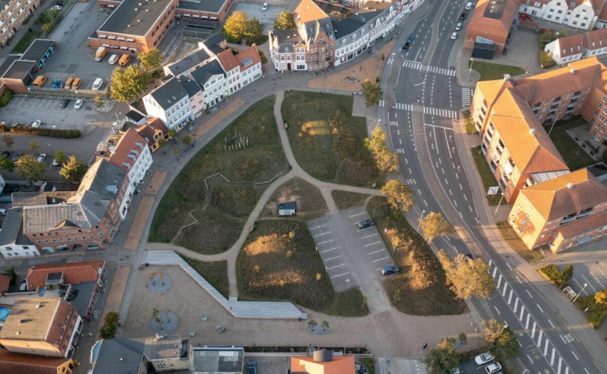 Luftfoto af den grønne plet Nørreport med grå stier og huse og bygninger på alle sider