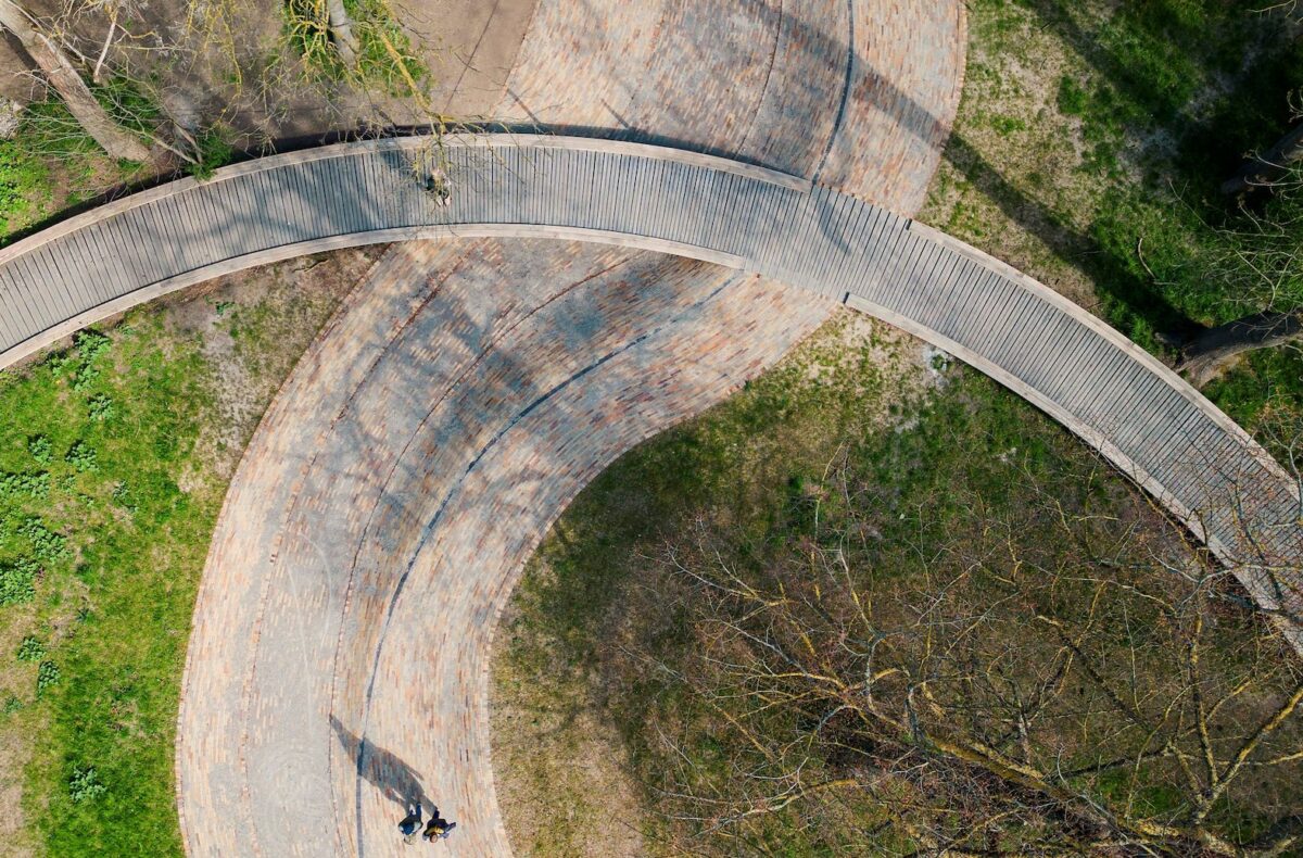 Luftfoto af den teglklinkebelagte flodseng - her skåret over af cirkelbroen i træ