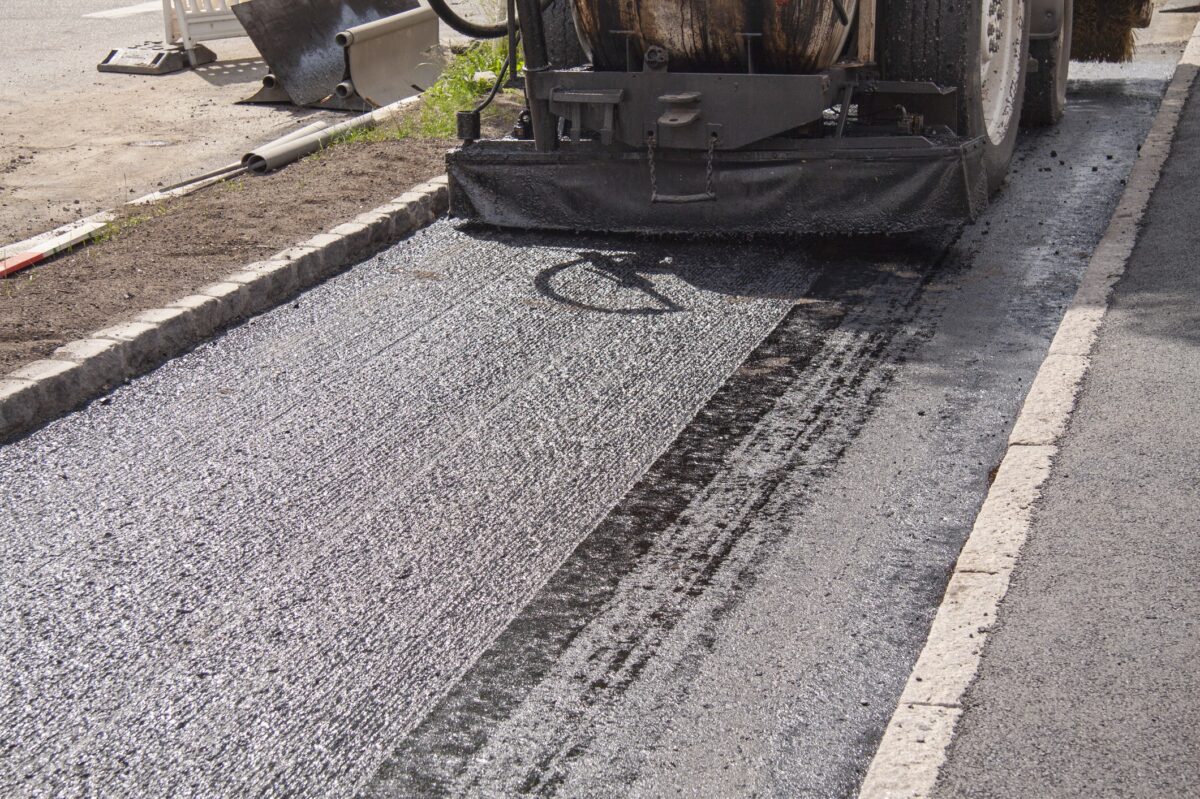 Foto af en asfaltvogn, der lægger våd asfalt på en cykelsti