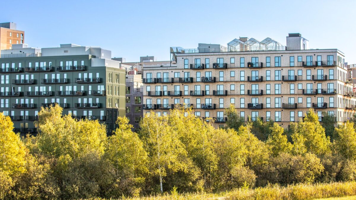 Foto af store boligkomplekser med masser af grønt foran