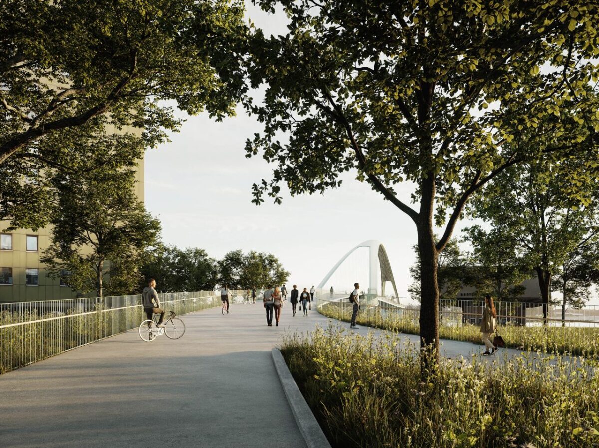 Kig til brobuerne fra en grøn park med stier, der leder gående og cyklister ud på broen