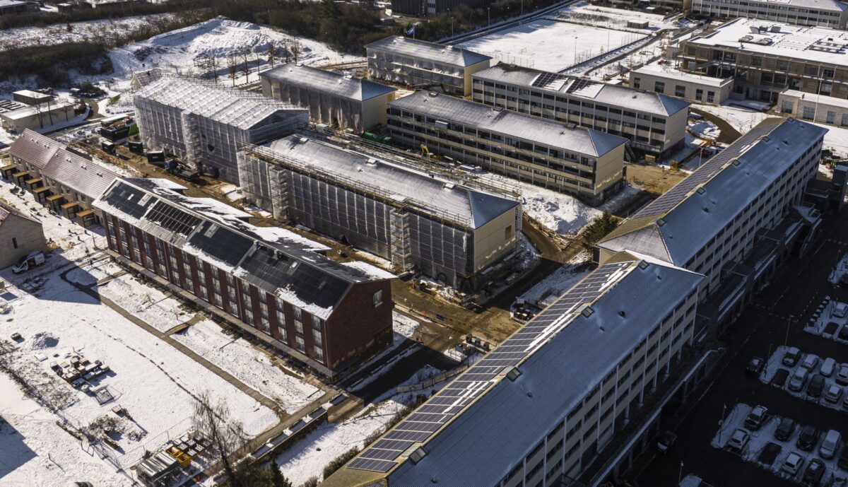 luftfoto af et boligområde med mange boligblokke. Nogen af dem er pakket ind i stilladser og plastic