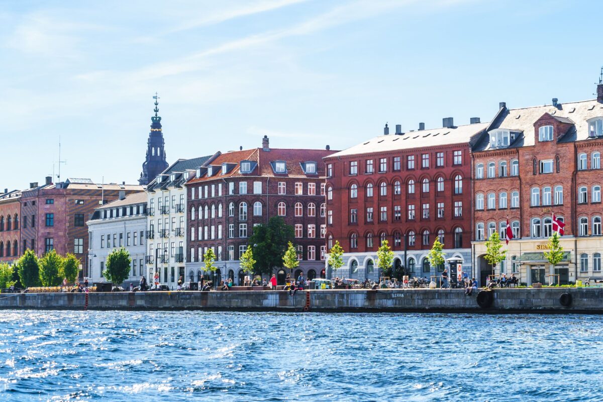 Mennesker færdes langs kanal i København.