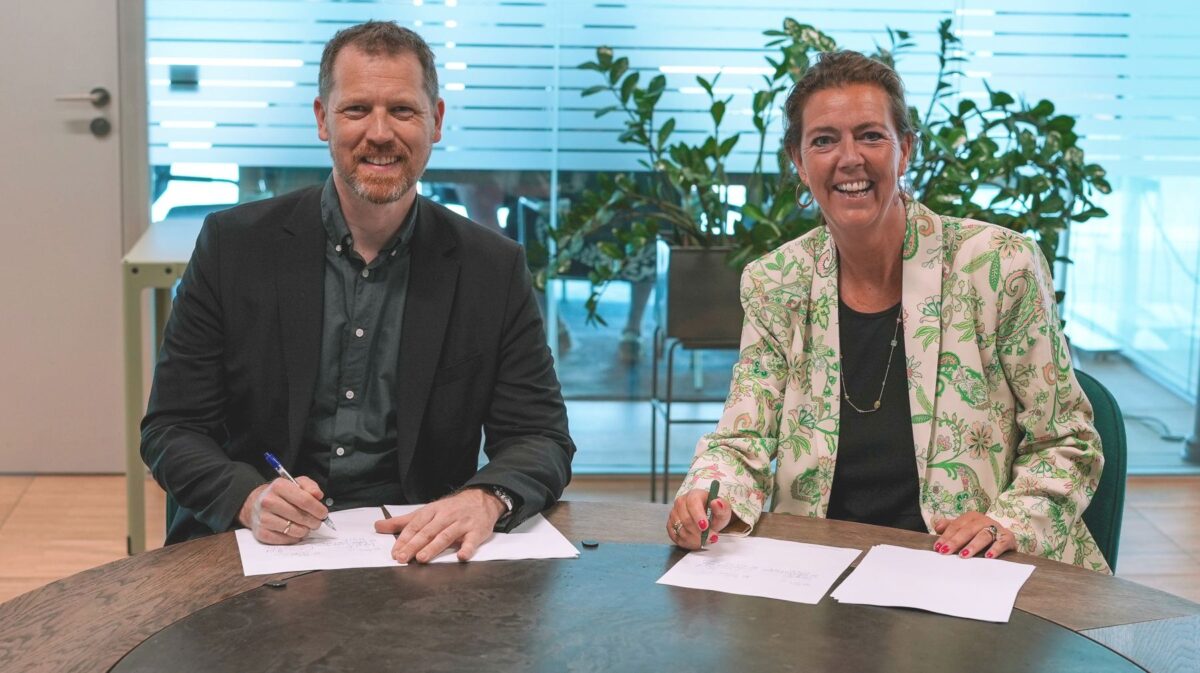 Kasper Lynge Jensen og Christina Hvid med hvert deres papir klar til underskrift