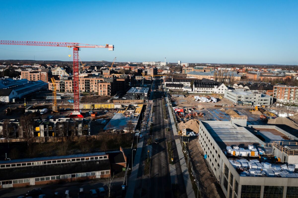 dronefoto af et byområde unde udvikling. Der står bl.a. en stor gul kran ude til venstre