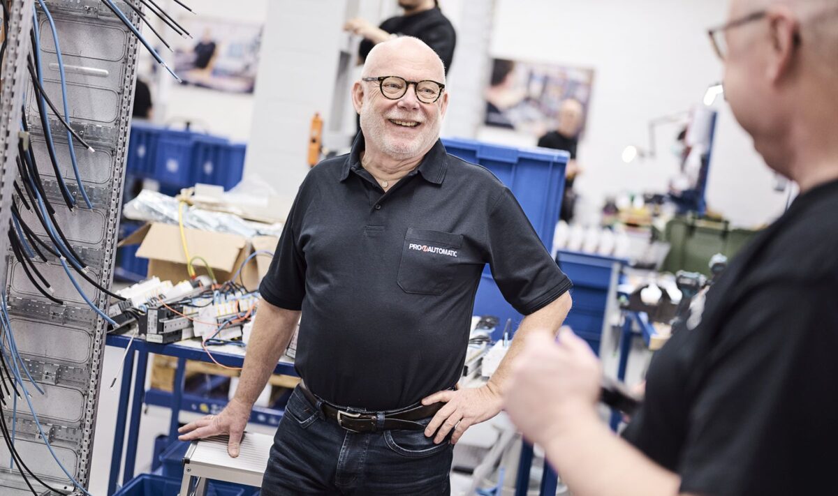 foto af mand i sort polo i produktionslokaler
