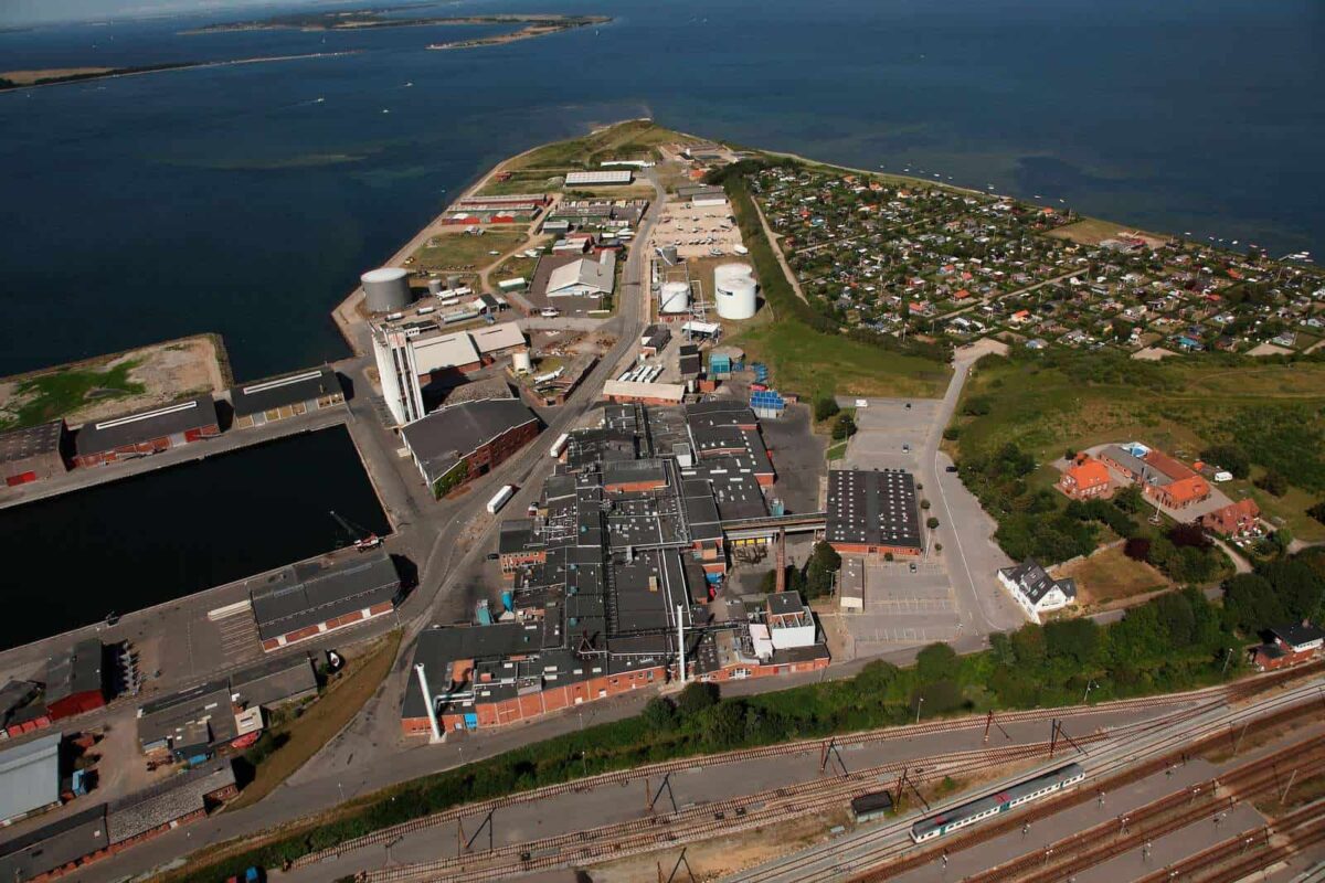 Luftfoto af et havneområde hvor der er forgrunden ses en stor mørkegrå bygning