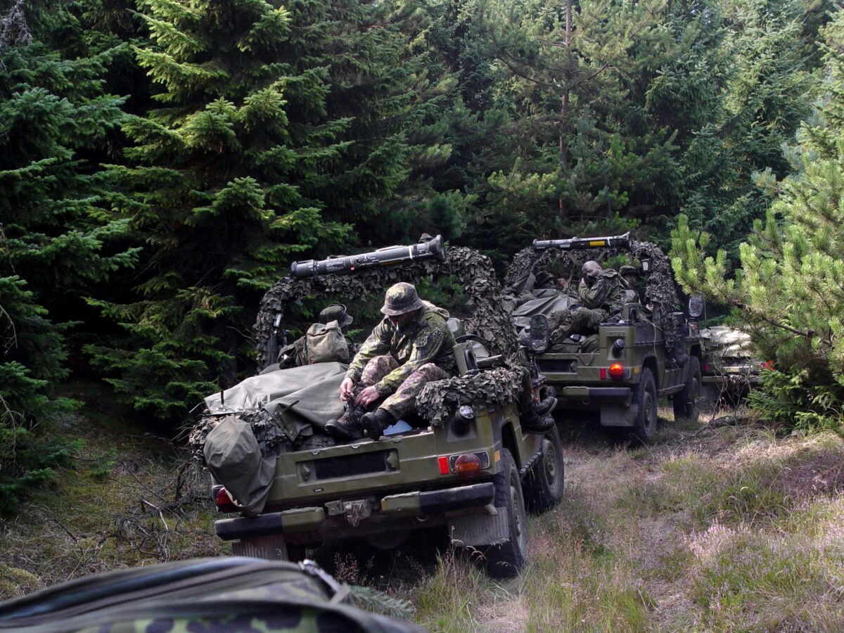 Mennesker i camouflagetøj i militærkøretøjer