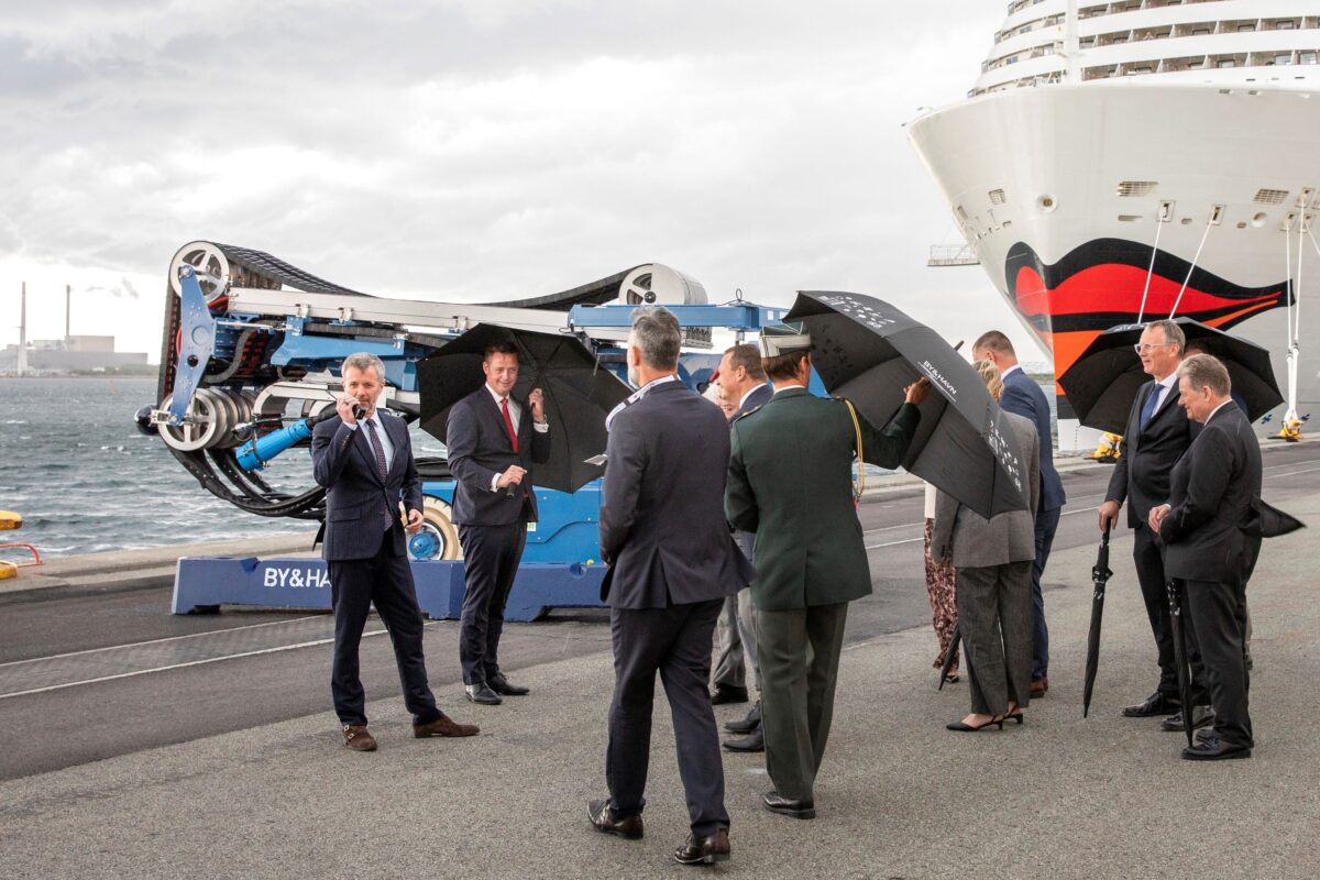 En gruppe mennesker og H.M. Kongen i Nordhavn. I baggrunden ligger et krydstogtskib til.