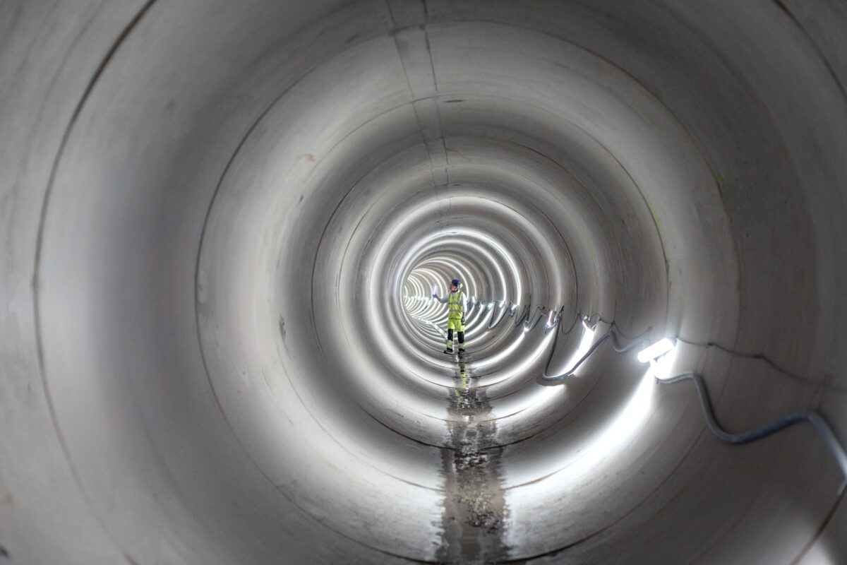 En mand står i en skybrudstunnel