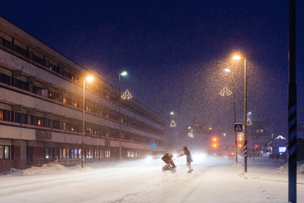 Kvinde med barnevogn krydser gaden i Nuuk
