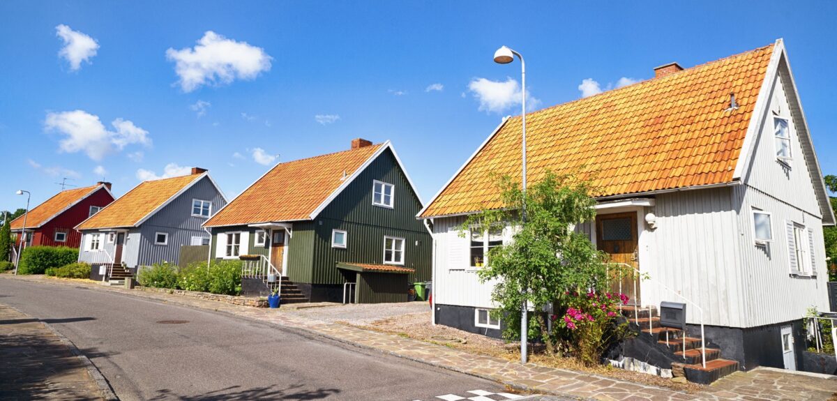 Fire boliger i forskellige farver, alle med røde tage.
