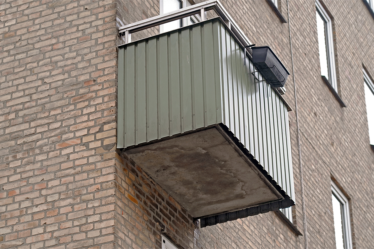 En grøn, udragende altankonstruktion.