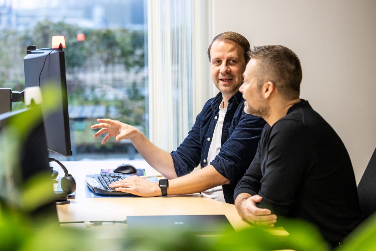 To personer sidder ved computerskærm