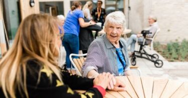 En ældre dame sidder ved et bord